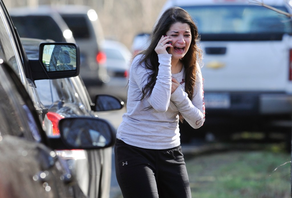 A woman crying while talking on her cell phone in a parking lot