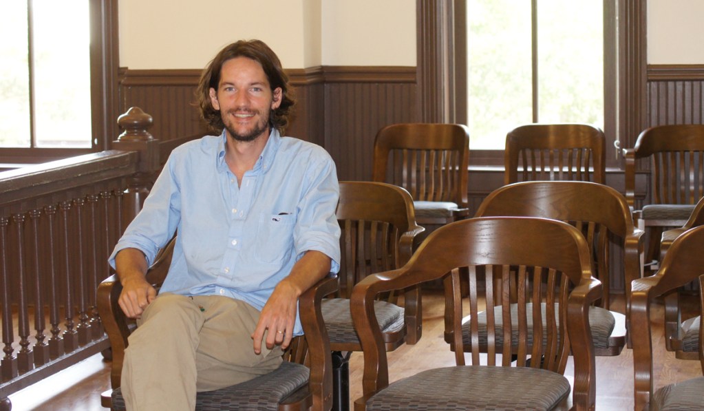 Patrick Weems sits in a wooden chair inside a courtroom