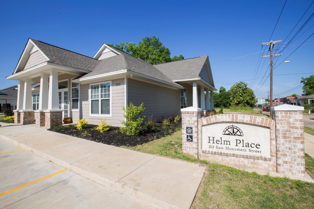 A home with a sign next to it that reads, “Helm Place, 203 East Monument Street.”