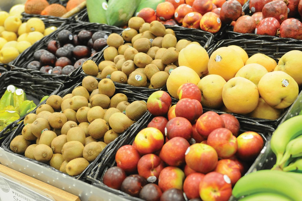 a photo shows various vegetables and fruits in a grocery aisle