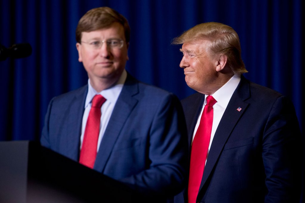 a photo of donald trump standing behind tate reeves, smiling