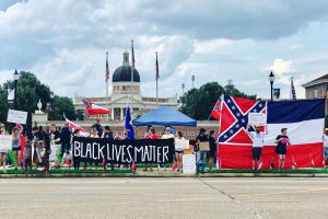 A rally with "Black Lives Matter" and the old MS Flag