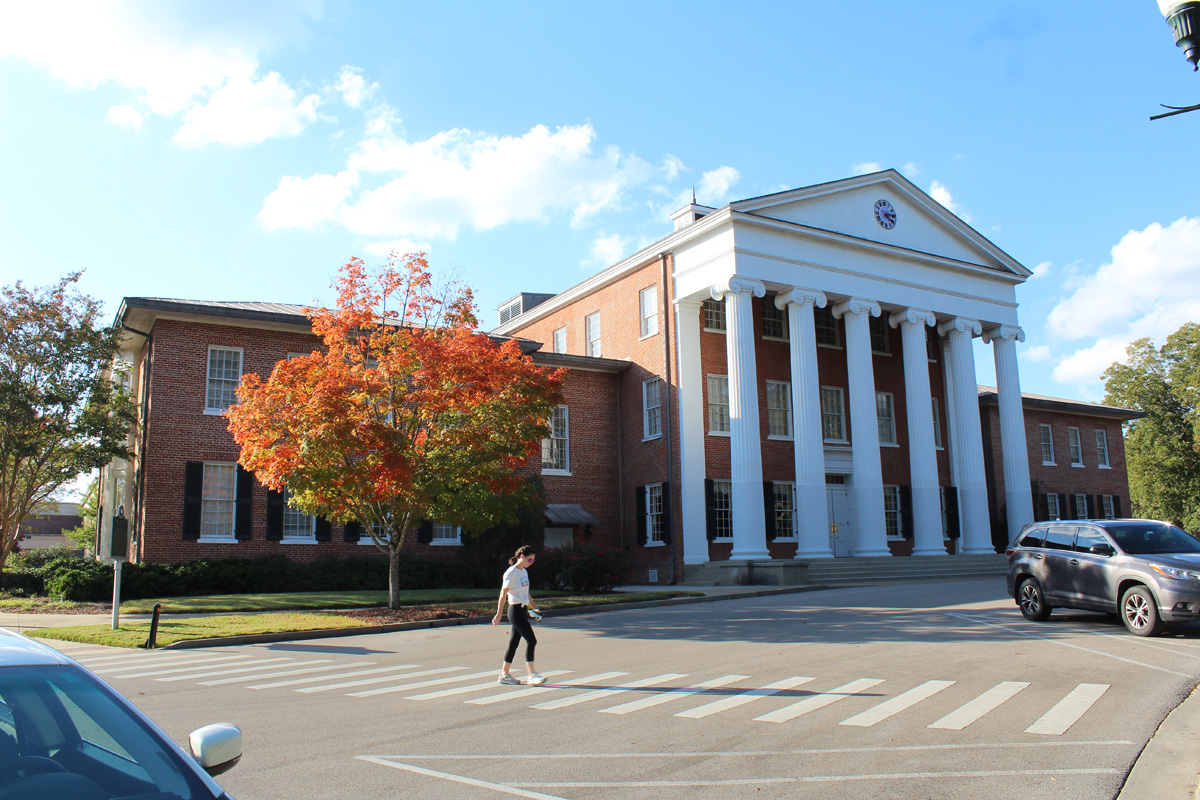 A student crosses in front of the Lyceum at the University of Mississippi in late October