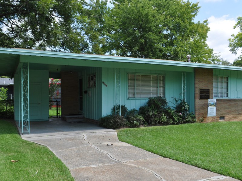 An exterior view of a green midcentury style home
