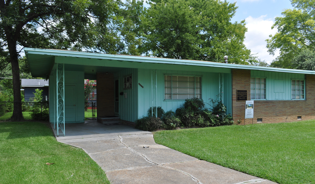 An exterior view of a green midcentury style home