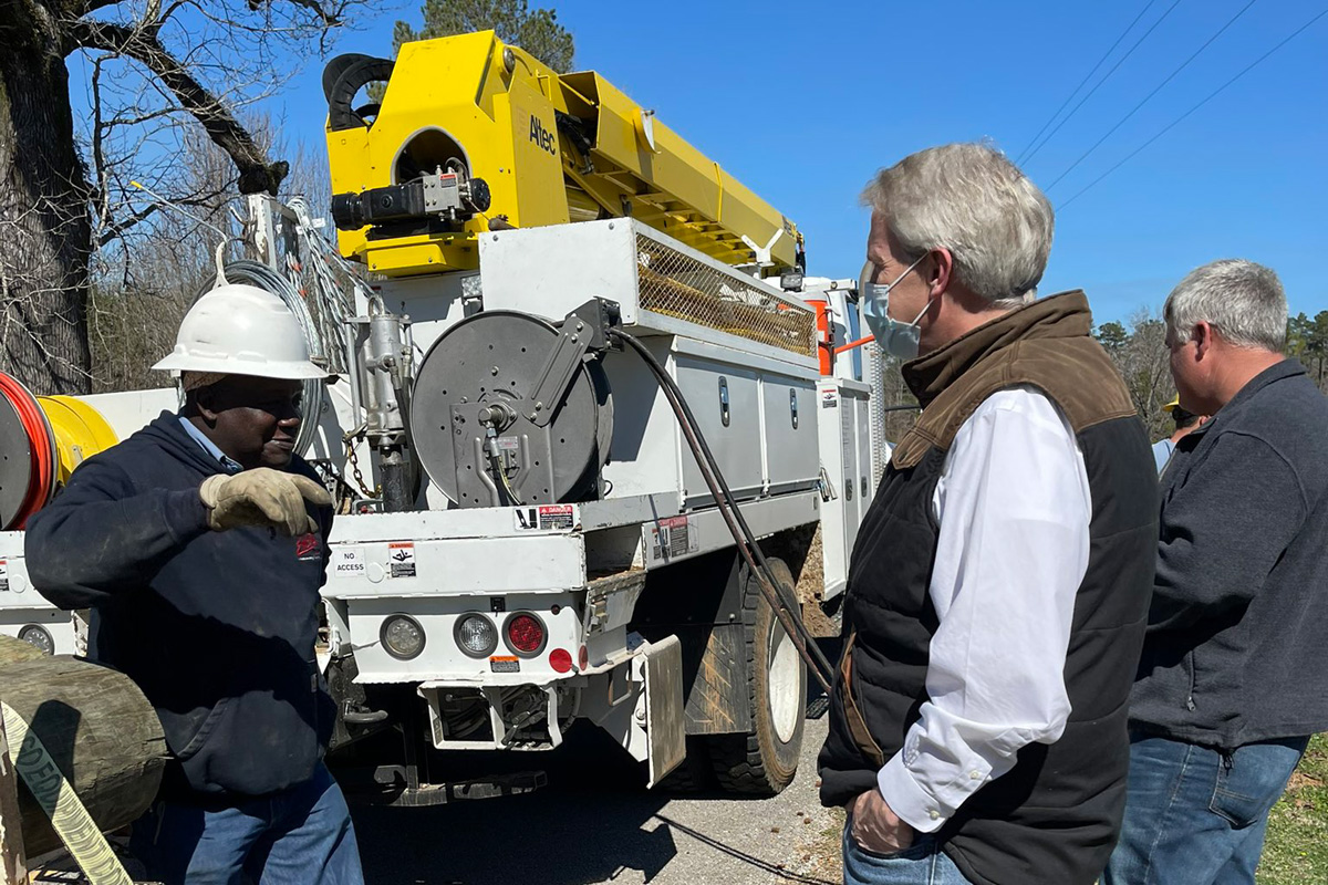 Three men standing in front of a white utility truck