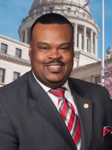 Official headshot of Kabir Karriem in front of the Mississippi State Capitol building