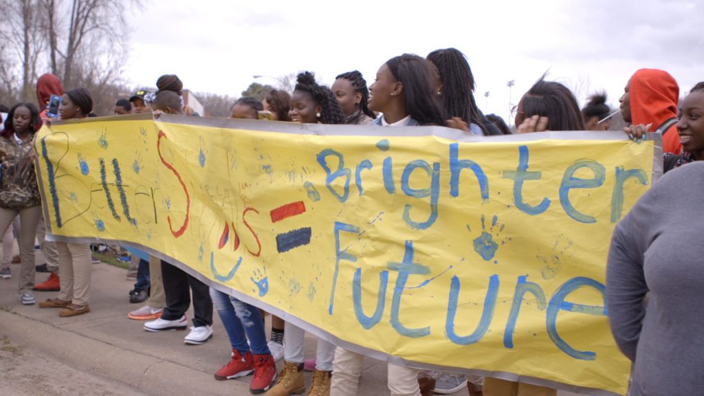 Teens holding a bright yellow banner