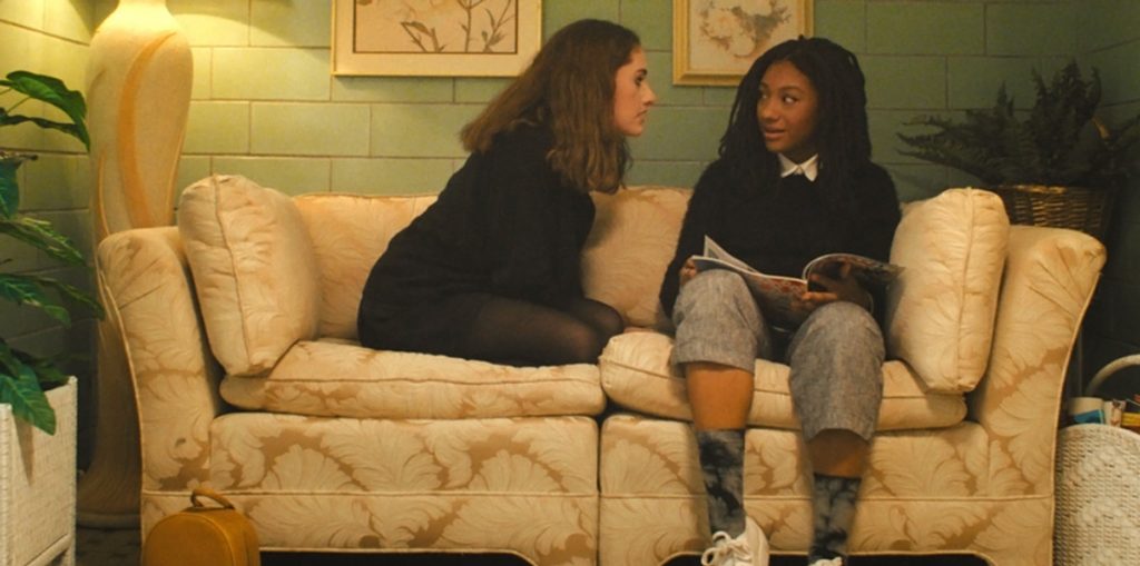 Two girls talking on a couch