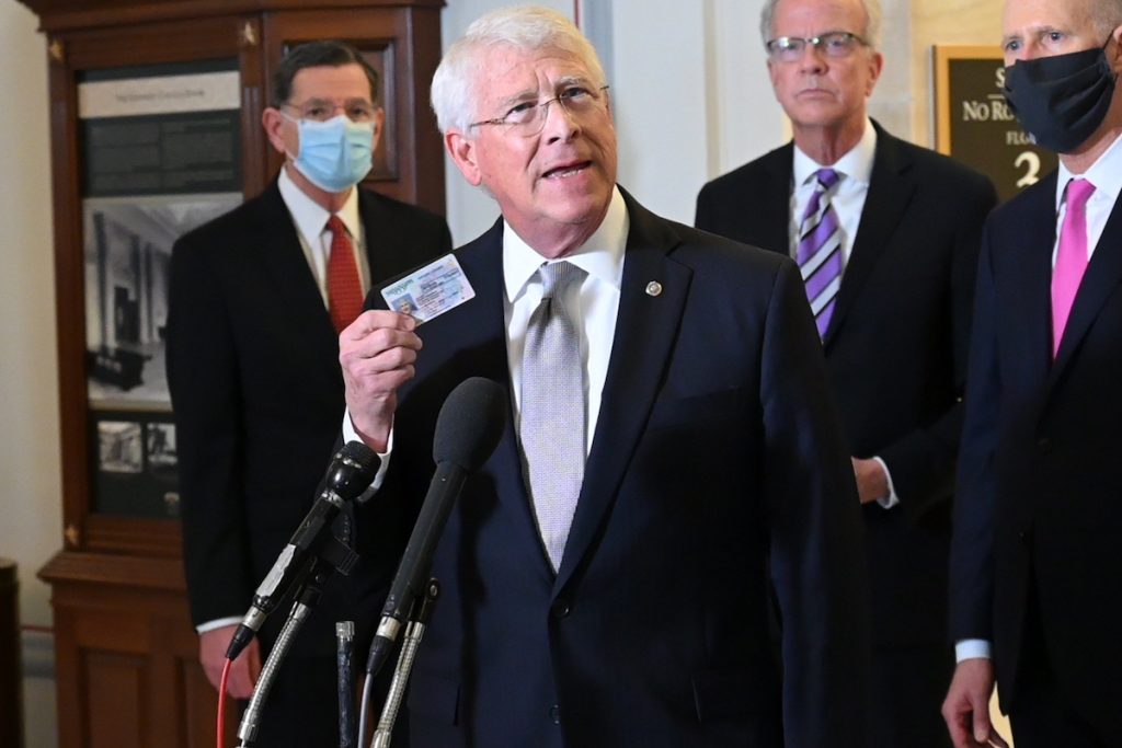 Senator Roger Wicker holds up a copy of a driver's license at a press conference