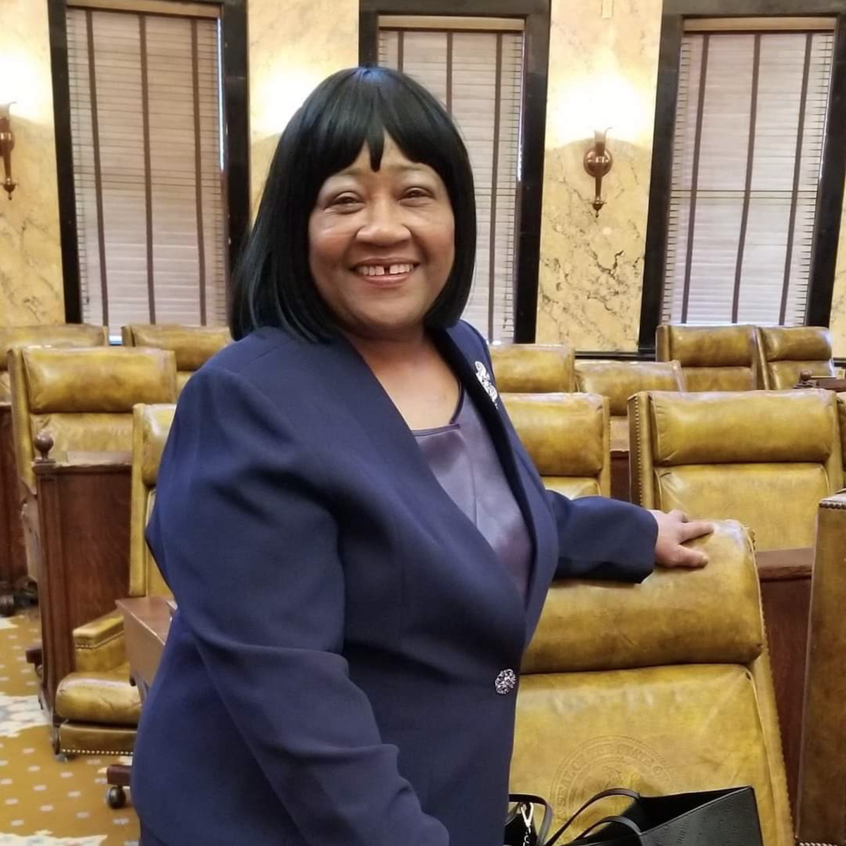 Representative Hestor Jackson-McCray poses next to her chair on the Mississippi House floor