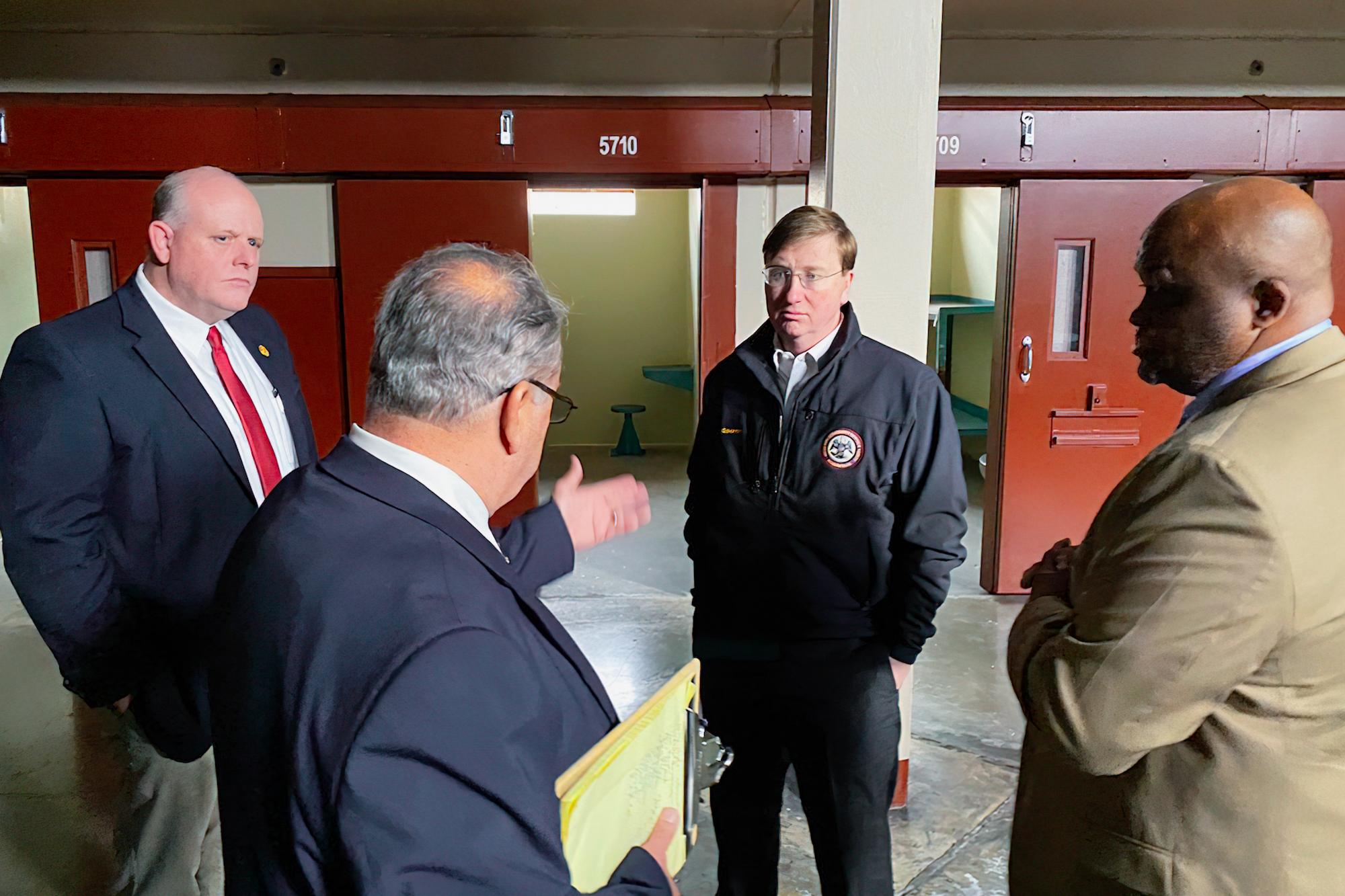 Governor Tate Reeves stands inside Parchman prison with men standing around him