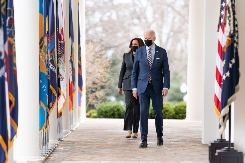President Biden and Vice President Kamala Harris walk down a breezeway outside the White House