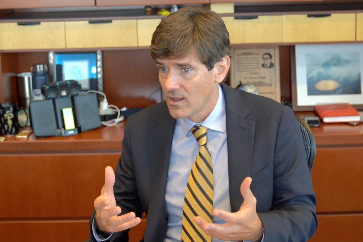 Thomas Dobbs speaking at his desk