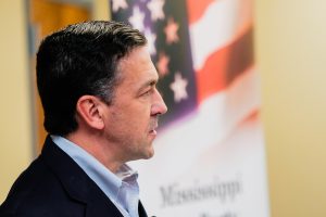 Sen. Chris McDaniel's side profile is visible as he listens to someone ask a question, the image of an American flag is visible in the background behind him
