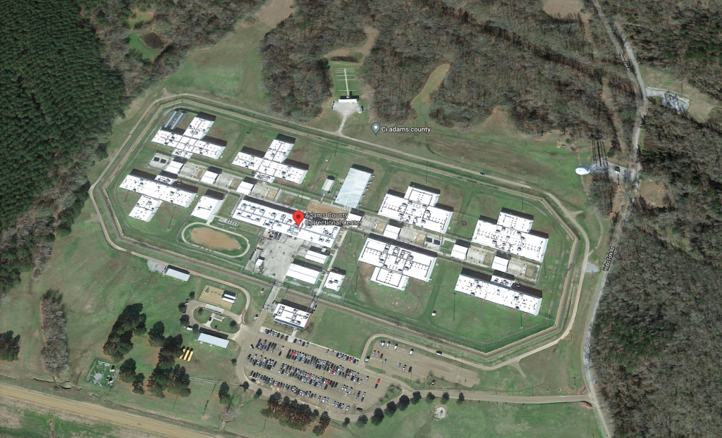 A Google maps image showing an aerial view of the Adams County Detention Center and its sprawling buildings surrounded by trees