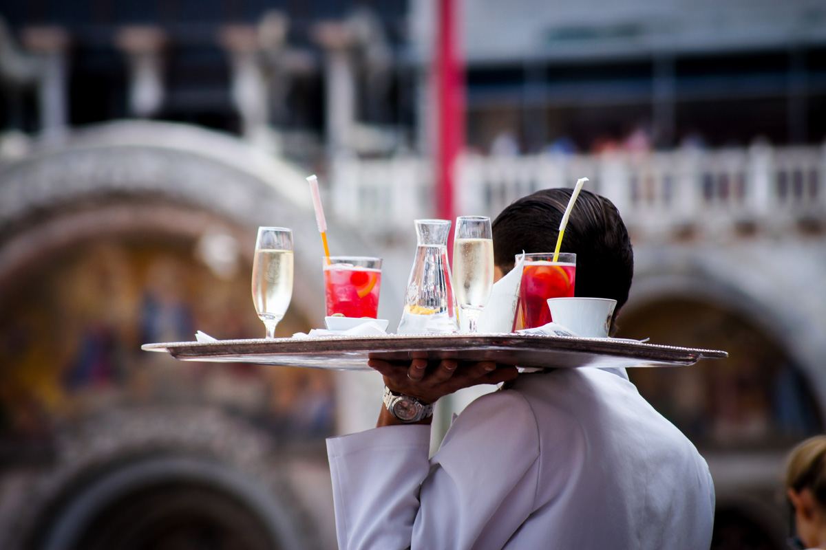 Waiter with a tray holding drinks