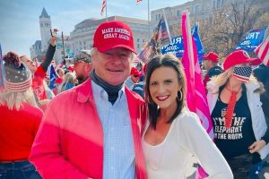 Eddie Nabors, wearing a red MAGA hat, poses with his daughter, Laura, at the Million MAGA March in D.C. with other marches behind them