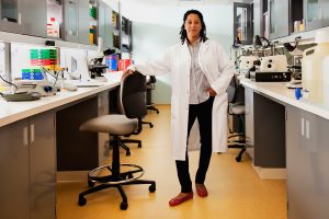 Black woman wearing a lab coat in a medical lab