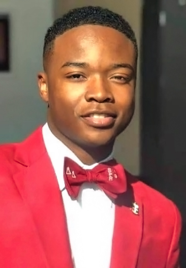 Cameron Wilborn wearing a white button down shirt, red jacket and red bowtie