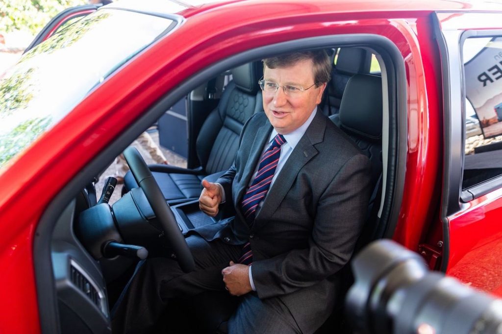 Tate Reeves sits in a red Nissan Frontier