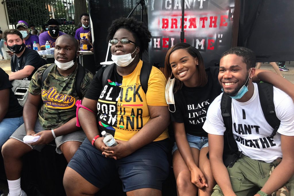 a photo of four young Black activists sitting together outside the governor's mansion