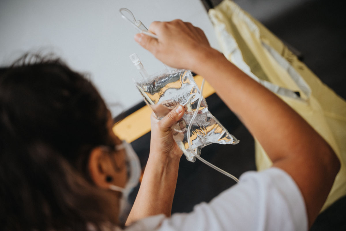 Masked doctor with saline bag