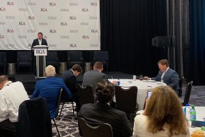 Governor Reeves sits at a table at an RGA event while another Republican governor speaks
