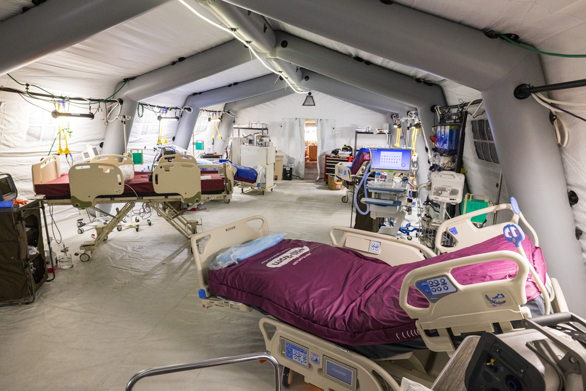 Maroon and white hospital beds inside of a field hospital