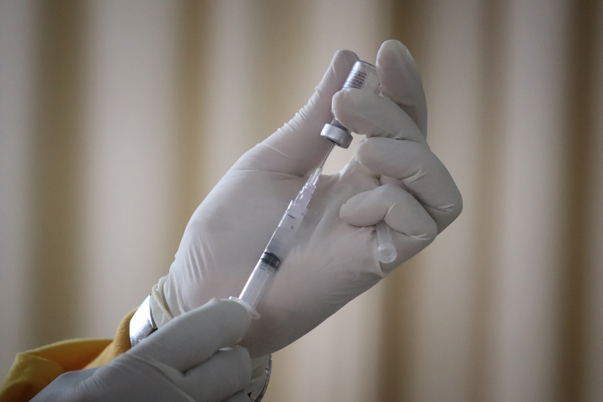 gloved hands preparing a covid-19 vaccination