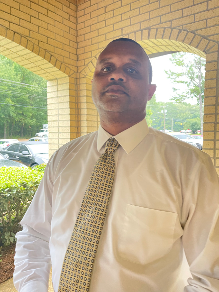 Jim Hill High School Principal Bobby D. Brown wearing a white shirt and yellow dotted tie