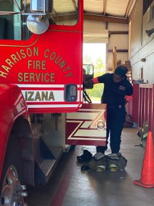 Lavonda Aldrich doing maintenance on teh side of a Harrison County Fire Truck