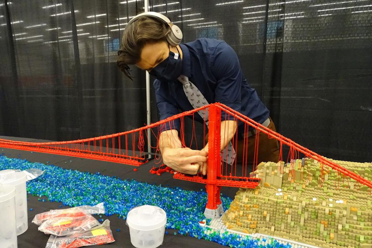 Rocco Buttlier assembling a lego build of the Golden Gate Bridge