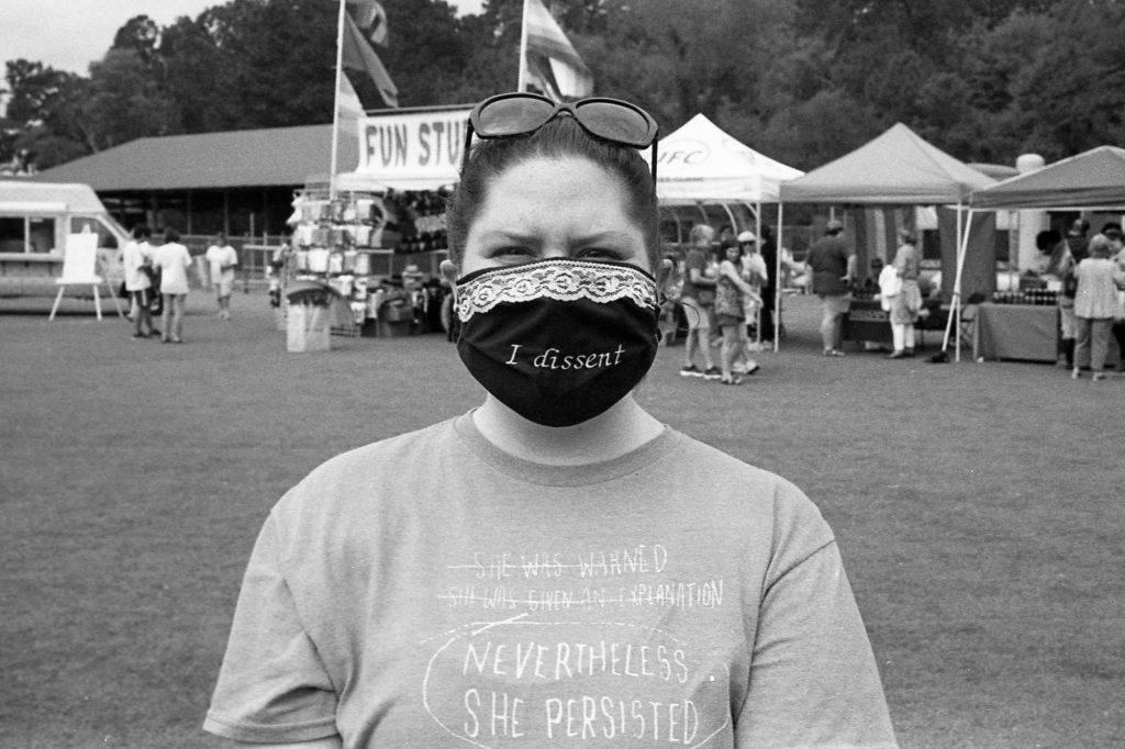 Photo of a woman with an "I Dissent" mask modeled after Ruth Bader Ginsburg's fashion