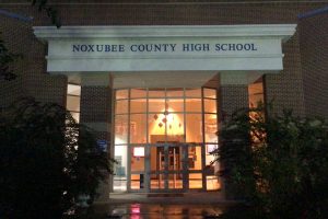 rick building with a sign that says The front doors of Noxubee County High School