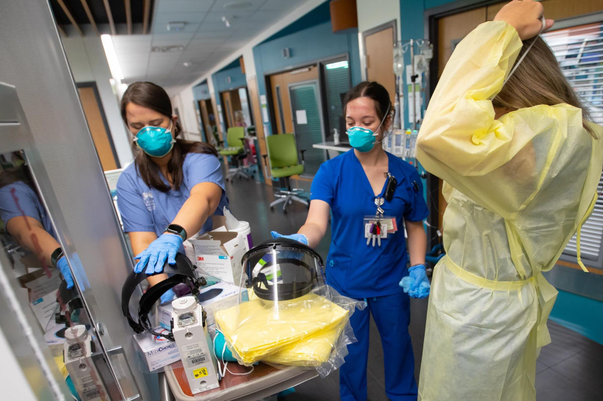 Registered nurses Haley Williams, left, and Abagael Mathis, center, sanitize their PPE shields after checking on a COVID-19 patient in the intensive care unit at Children's of Mississippi.