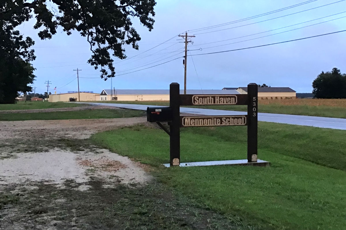 Sign in front of Mennonite school in Noxubee County with expansive farmlands in the background