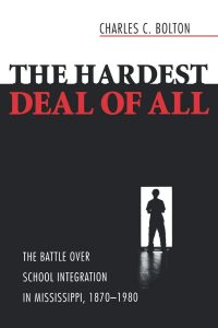 Book cover of The Hardest Deal of All. The graphic is a black wall with the silhouette of a man against a white doorway