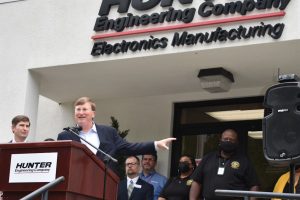 Tate Reeves stands at a podium outside Hunter Engineering