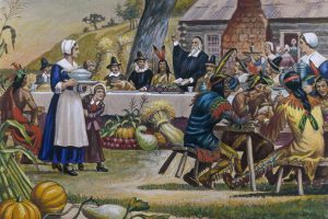Artistic vision of pilgrims and Native Americans eating at Thanksgiving