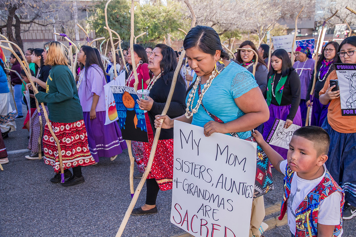 Native American women marching with signs