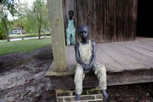 Statues of young boys on a wooden porch