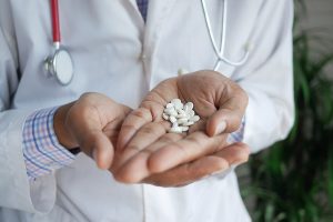 doctor holding medical pill on palm of hand