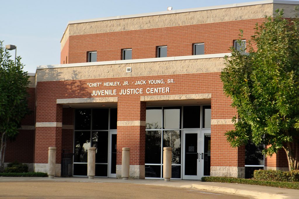 Photo of a red brick building that says "Chet" Henley, Jr - Jack Young Sr Juvenile Justice Center