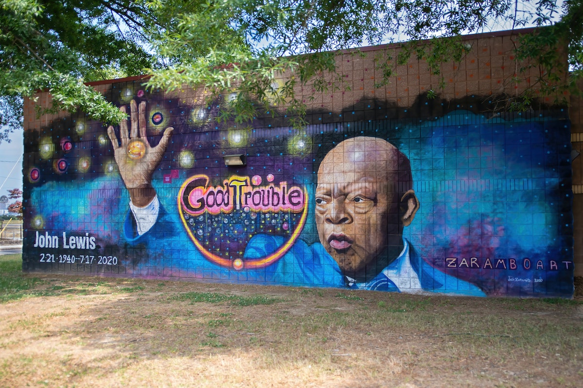 Space background mural with John Lewis at the front and "Good Trouble" beside him