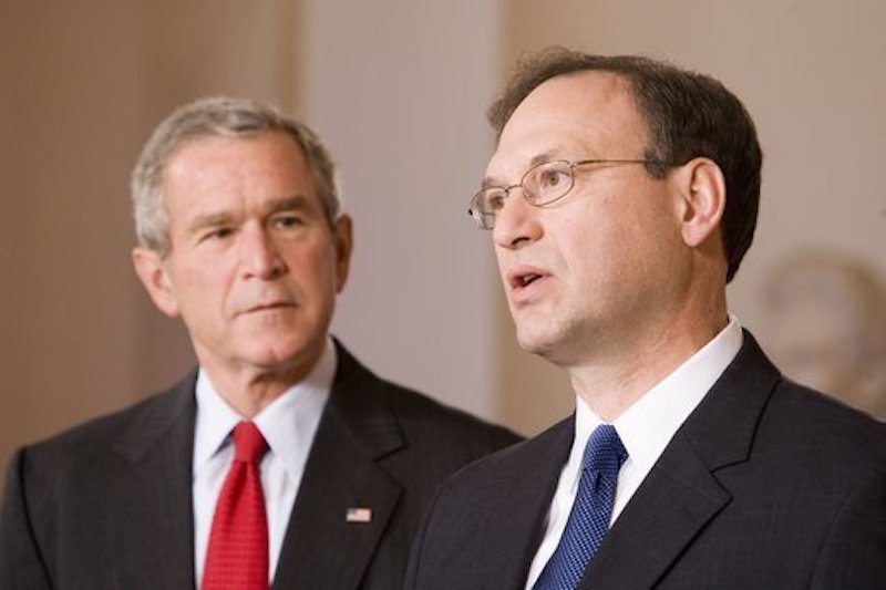a photo of George Bush looking at Samuel Alito