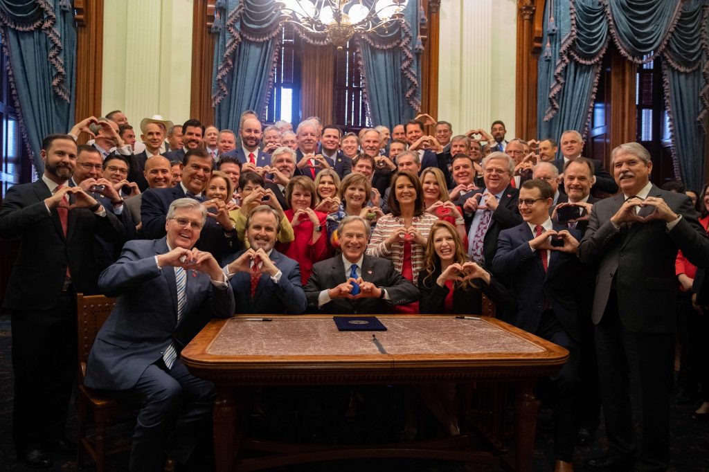 a photo of Texas Republicans holding their hands up in heart signs, including Gov Greg Abbott