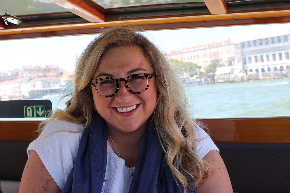 Smiling woman sitting on a boat in Venice