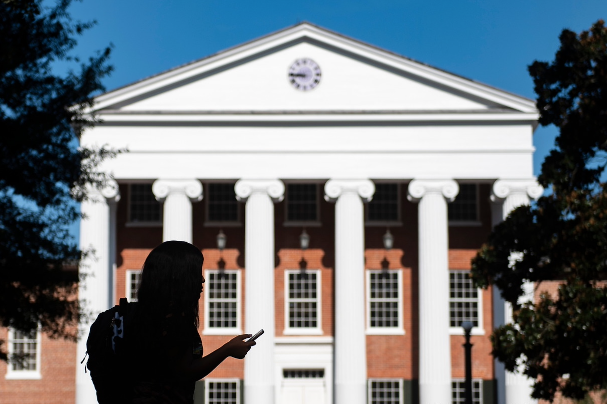 a photo of a student silhouetted in front of UM's Lyceum