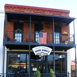 A two story red brick building with black iron porches